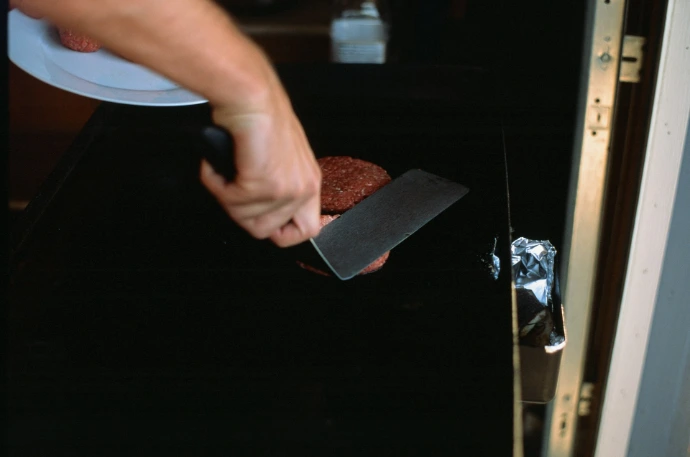 a person using a knife to cut a piece of food